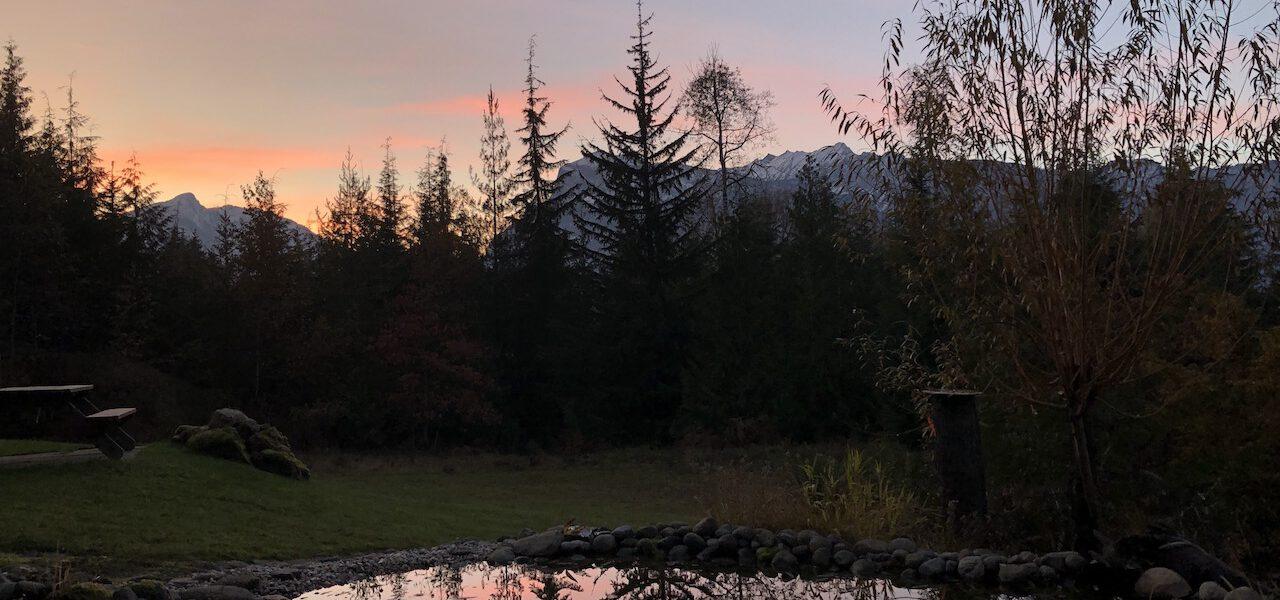 Mountain sunset with reflective pond in foreground