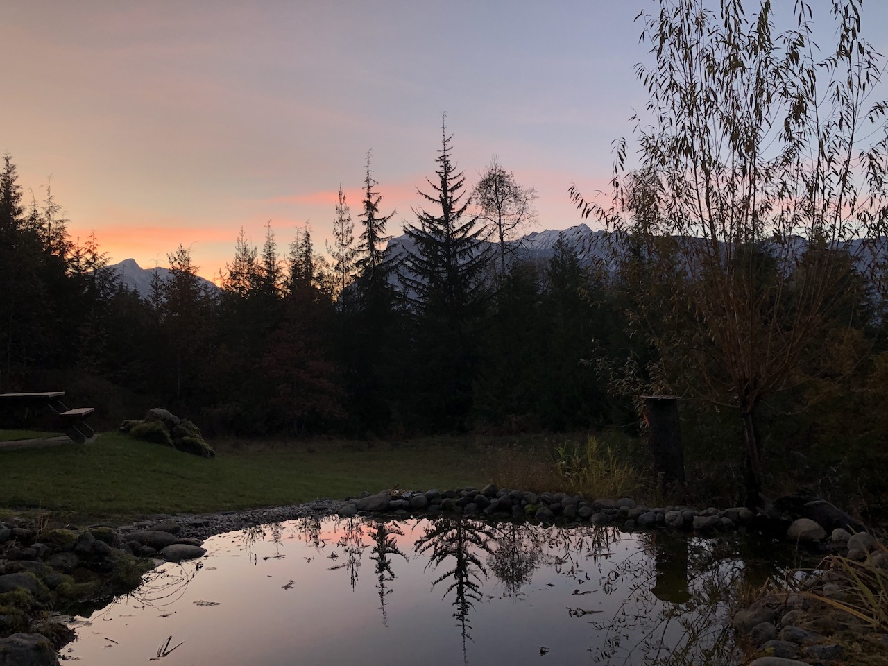 Mountain sunset with reflective pond in foreground