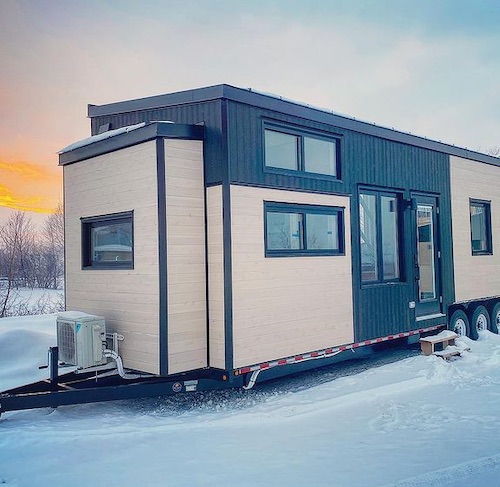 large Minimaliste tiny house on wheels in snowy field