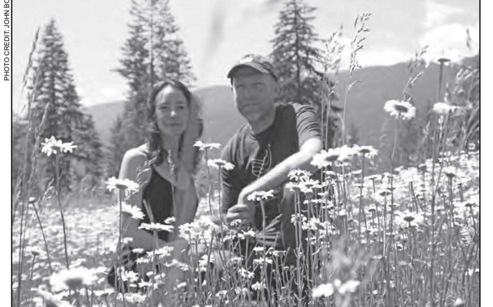 Black and white photo of a couple in a field of flowers