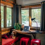 Cozy tiny house interior with small dog on a couch near a window